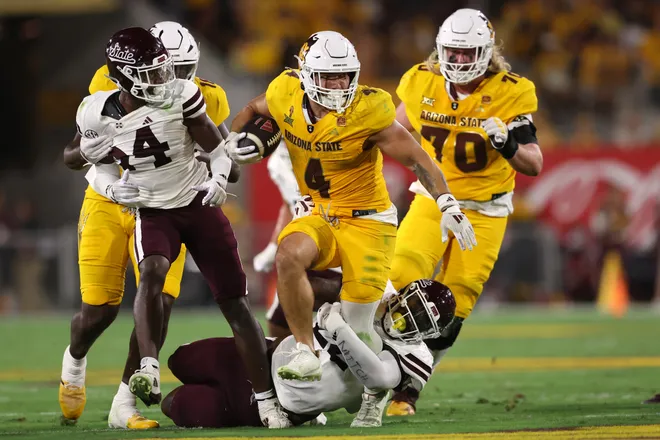 Running back Cam Skattebo #4 of the Arizona State Sun Devils slips through a tackle by defensive lineman Kedrick Bingley-Jones #22 of the Mississippi State Bulldogs during the first half at Mountain America Stadium on Sept. 7, 2024 in Tempe. Chris Coduto/Getty Images