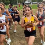 Tupelo Invitational 2026 results: Oxford boys, Tupelo girls win 5A–7A titles Girls cross country runners race on a grass course, including athletes wearing Houston and Ripley uniforms.